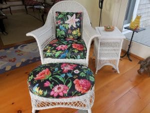 Antique Wicker Chair and Matching Foot Stool | Upholstered in a Schumacher Chintz Floral Print | Upholstered by Cape Cod Upholstery Shop | Located in South Dennis, MA