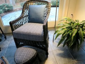 Black wicker chair and foot stool with removable seat cushion and back pillow | Upholstered in a Stout Fabrics and Greenhouse Fabrics stripe and solid | Upholstered by Cape Cod Upholstery Shop | Located in South Dennis, MA 02660