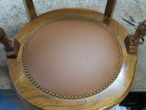 Round Desk Chair Seat | Upholstered in a Greenhouse Fabrics faux leather to match the existing vinyl on the chair back | Decorative French Natural nail trim | Upholstered by Cape Cod Upholstery Shop | Located in South Dennis, MA 02660