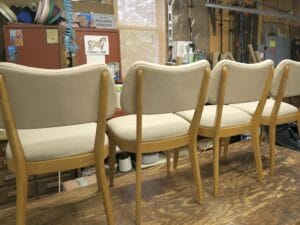 Set of 4 vintage Heywood Wakefield chairs shown from the back | Upholstered in a Sunbrella Spectrum-Sand fabric | Upholstered by Cape Cod Upholstery Shop | Located in South Dennis, MA 02660