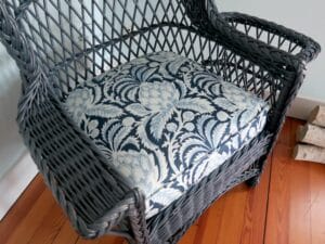 Up close view of one of two matching wicker wing chair seat cushions | Upholstered in in a blue linen print fabric | Upholstered by Cape Cod Upholstery Shop | Located in South Dennis, MA 02660