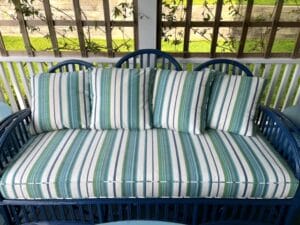 Blue Wicker sofa on a covered porch | Cushion covers fabricated in a Perennials stripe indoor-outdoor fabric | Cushion inserts are rated for outdoor use | Cushions fabricated by Cape Cod Upholstery Shop | Located in South Dennis, MA 02660