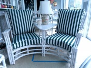 Vintage curved Rattan Settee with two separate chairs attached in the middle by a table | Cushion covers upholstered with Sunbrella Mason Forest Green stripe and outdoor rated cushion inserts | Upholstered by Cape Cod Upholstery Shop | Located in South Dennis, MA 02660