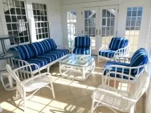 Rattan chairs and sofa. Sunbrella Milano Cobalt. Three season room with white rattan chairs and sofa. Cushions fabricated with Sunbrella Milano Cobalt. All new CertiPur-US upholstery foam. Cushions fabricated by Cape Cod Upholstery Shop - South Dennis, MA 02660