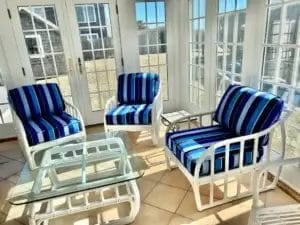 Rattan chairs and sofa. Sunbrella Milano Cobalt. Three season room with white rattan chairs and sofa. Cushions fabricated with Sunbrella Milano Cobalt. All new CertiPur-US upholstery foam. Cushions fabricated by Cape Cod Upholstery Shop - South Dennis, MA 02660